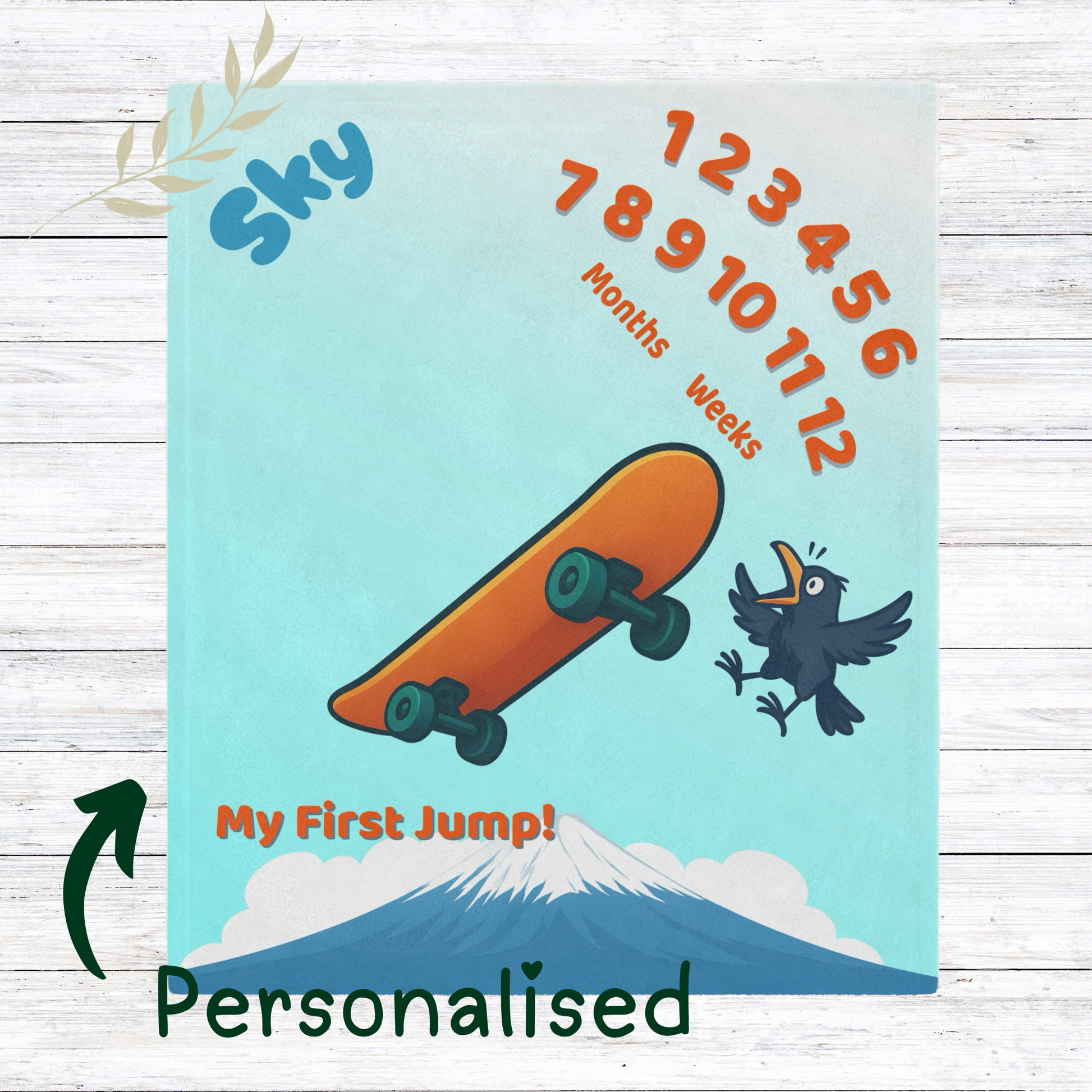 “Skateboard-themed baby milestone blanket with bright orange board, excited cartoon bird, Mt. Fuji in the background, and ‘My First Jump!’ text. Sherpa fleece backing, perfect for weekly or monthly baby photo sessions.”

