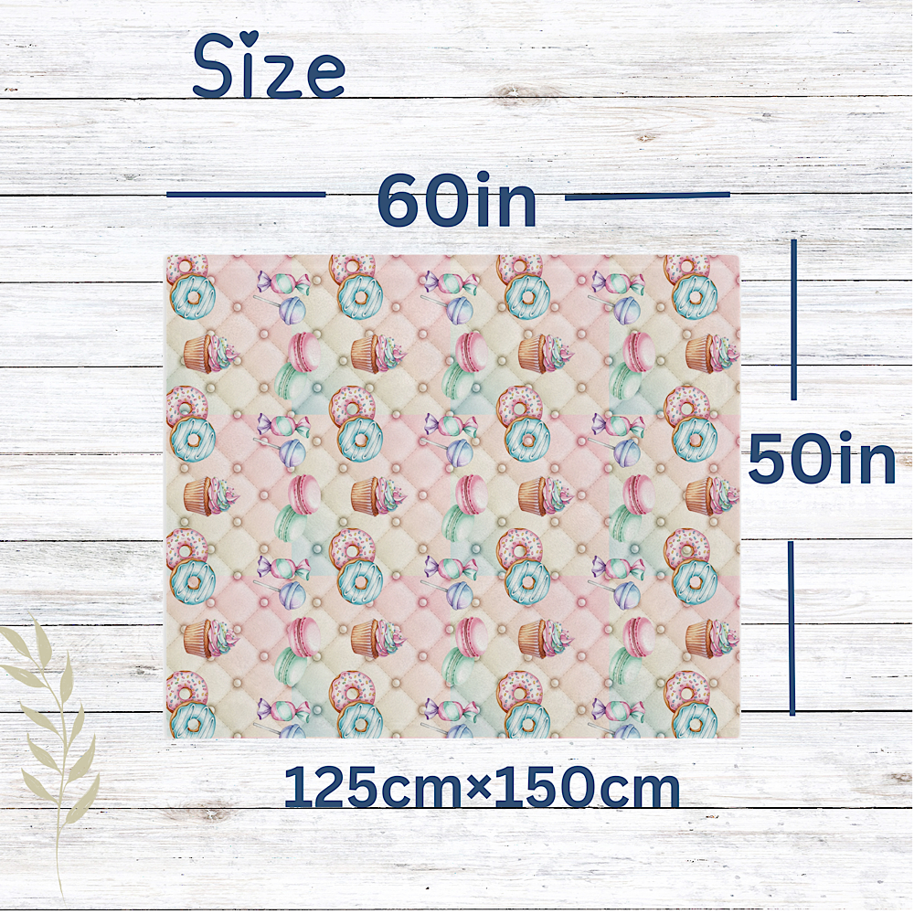 Sweets Patterned pink throw blanket with dimensions 60in x 50in on a wooden background