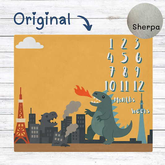 Baby milestone blanket with kaiju design and number sequence on an yellow background