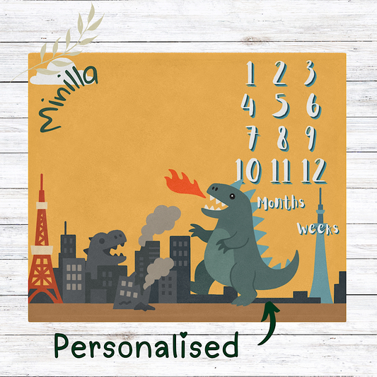 Yellow personalised baby milestone blanket with cute kaiju monster and cityscape, monthly photo backdrop