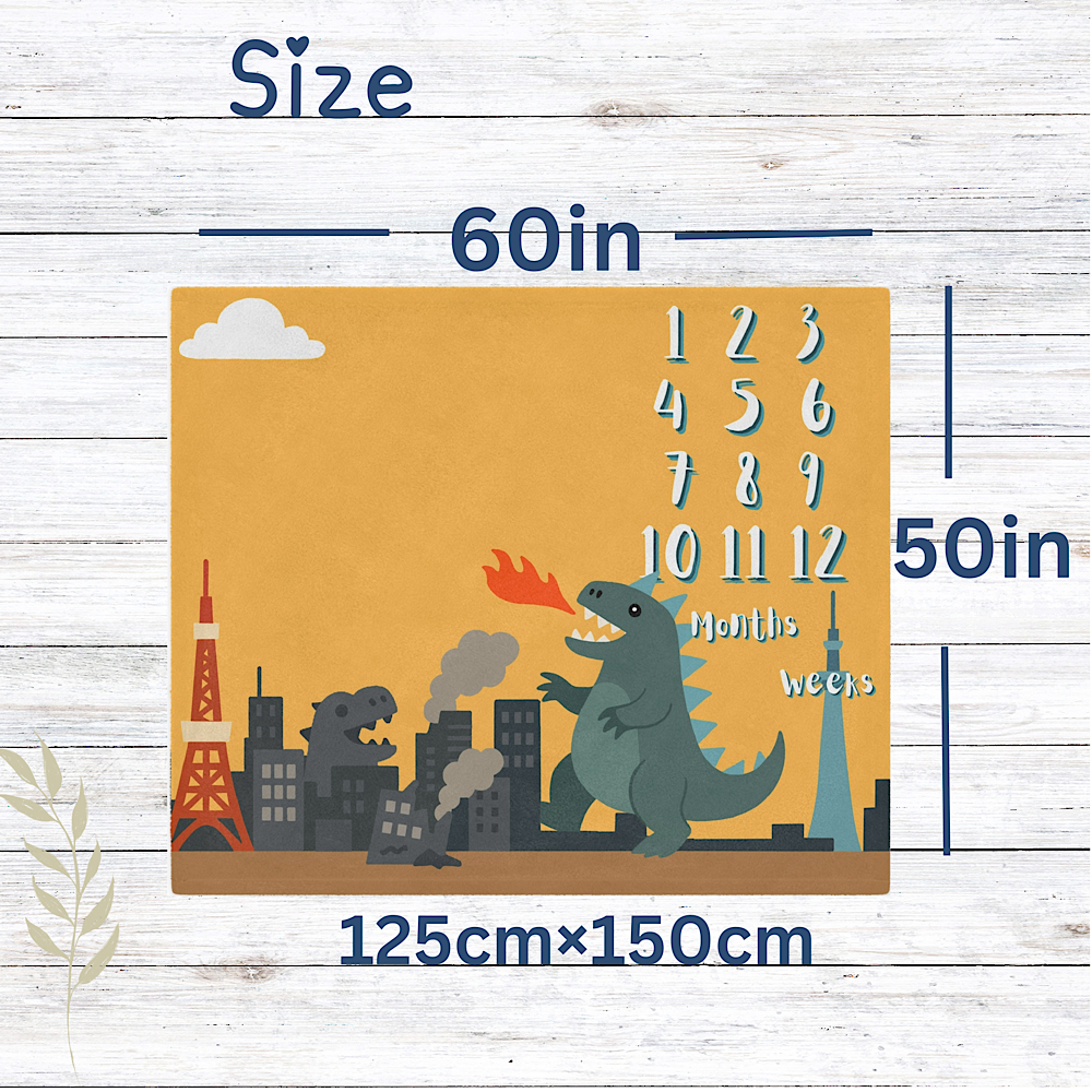 Yellow personalised Baby milestone blanket banner with Kaiju design on a wooden background